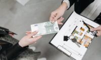 Mains echangeant des billets au-dessus d un plan d appartement et d un jeu de cles